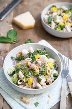 two bowls filled with food sitting on top of a wooden table next to silverware