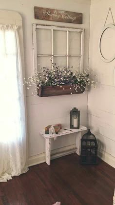 a room with a window and some flowers on the table next to a candle holder