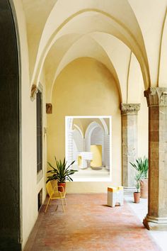 an arched hallway with chairs and potted plants