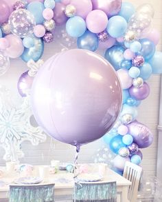 there is a balloon and some chairs in front of a table with balloons on it