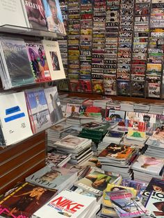 there are many magazines on the table in this store that is full of people's books