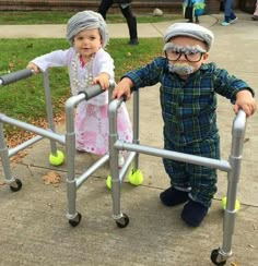 two small children standing next to each other on top of a metal frame with tennis balls