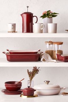 red pots and pans on shelves with white walls in the background, including one holding a teapot