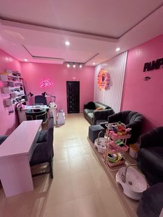 a room with pink walls and black couches