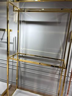 a gold and glass shelf in a room