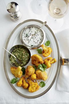 a white plate topped with fried food and dipping sauce