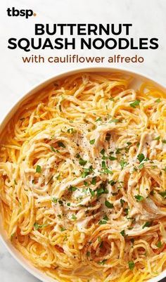 a white bowl filled with pasta and topped with parsley