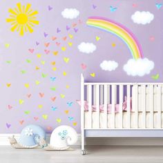 a baby's room with a crib and rainbow wall decals