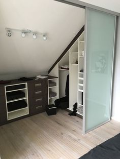 an attic bedroom with sliding glass doors leading to the closet and dressing area in it