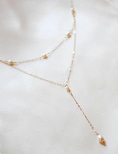 Our gorgeous ALEXANDRIA bridal backdrop necklace features a delicate gold chain embellished with a genuine freshwater pearls, perfect for accentuating your wedding day look. Crafted from the finest materials, this necklace adds a timeless classic effect to any gown. - Handcrafted in my studio in PA- Genuine Freshwater pearls- 14K gold filled chain- Nickel free and hypoallergenic- Choker necklace measures 15 inches and is adjustable to 17 inches- Backdrop in photos measures 7 inches (pick the len Pearl Back Necklace, Gold Wedding Necklace, Pearl Backdrop, Necklace For Bride, Bridal Jewelry Pearl, Bridal Backdrop, Bridal Backdrop Necklace, Bridal Backdrops, Gold Necklace Wedding