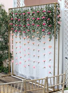 an outdoor wedding ceremony with pink flowers and greenery hanging from the side of the aisle