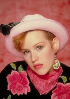 a woman wearing a pink hat with flowers on it