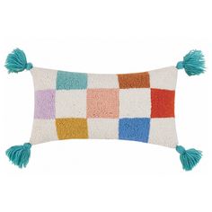 a multicolored pillow with tassels on the front and back sides, sitting against a white background