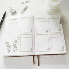 an open planner book sitting on top of a table