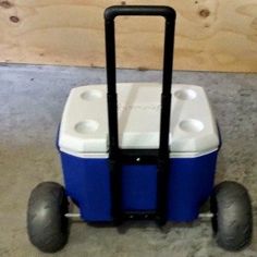 a blue and white cooler sitting on top of a dolly