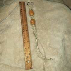 a measuring tape and wooden beads on a white blanket