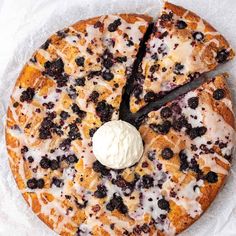 a blueberry cheesecake is cut into slices with a dollop of whipped cream on top