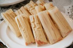 several pieces of tamales on a white plate