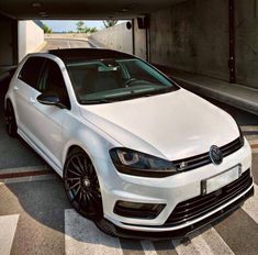 a white volkswagen car parked in a parking garage