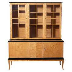 a wooden cabinet with glass doors and black trim on the bottom, against a white background