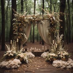 an outdoor wedding setup with white flowers and greenery on the ground, surrounded by candles