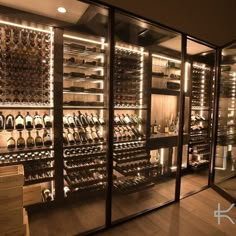 a wine cellar filled with lots of bottles and shelves full of wines in glass doors