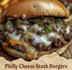 a cheese steak burger on a wooden table with a piece of wax paper in front of it