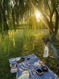 a blue and white blanket sitting on top of a grass covered field next to a bike