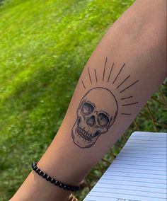 a person with a skull tattoo on their arm