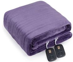 two remote controls are plugged in to a purple blanket that is rolled up on top of each other