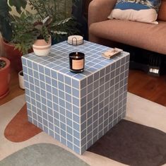 a blue and white box sitting on top of a rug next to a brown couch