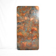 a piece of metal with rust and blue paint on it's surface, against a white background