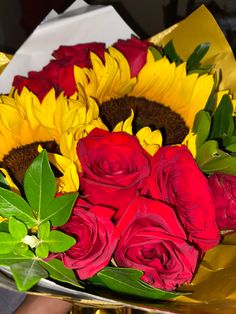 a bouquet of sunflowers and roses on a table