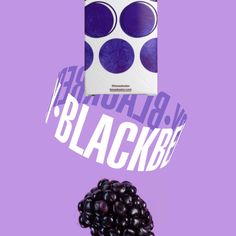 a package of blackberries sitting next to a pile of berries on a purple background