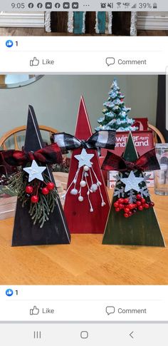 three wooden christmas trees sitting on top of a table next to each other with decorations