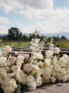 wedding flowers lined up on the side of a bench