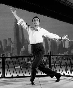 a man is dancing in front of a cityscape