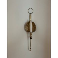 a wall mounted clock with a key hanging from it's side