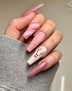 A playful yet chic pink manicure with glittery accents and charming Christmas details. Candy cane stripes, delicate snowflakes, and an adorable reindeer with festive antlers create a whimsical holiday vibe. The sparkly pink coffin-shaped nails offer a modern twist on traditional Christmas colors, making this design perfect for a fun and festive look. Christmas Nails On Brown Skin, Almond Shape Christmas Nail Designs, Winter Christmas Nails Coffin, Pink Xmas Nails Almond, Christmas Pink And Red Nails, Pink Sparkly Christmas Nails, Christmas Nails Acrylic Reindeer, Reindeer Nails Acrylic, Coffin Nails Christmas Designs