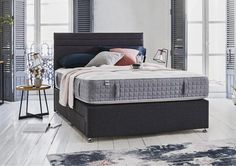 a bed sitting on top of a wooden floor next to a window