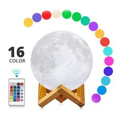 the moon lamp is sitting on top of a wooden stand with colorful lights around it