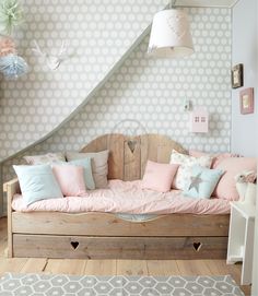 a couch with pillows on top of it in front of a wallpapered room