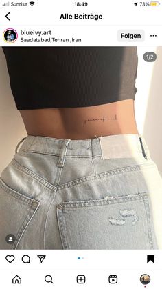 the back of a woman's stomach with an inscription on her left side, which reads