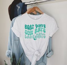 "⚓ Embrace lazy lake days with our \"Boat Wave, Sun Rays, Lake Days\" Shirt. Perfect as a gift for nature lovers, friends, and family, this stylish tee captures the essence of carefree lake vacations.  So why not add this lake life shirt to your collection today and show your love for the lake in style! 👕 PRODUCT INFO The Bella + Canvas shirts are super soft and comfy! These t-shirts are made of light fabric and have ribbed knit collars to bolster shaping. They are extremely durable, and will withstand years of repeat washing and wearing. Shoulders, sleeves, and hems have taping for better fit over time. ✏️ DESIGN Designs are printed onto the shirt using Direct to Garment (DTG), which means the ink is laid directly into the fabric resulting in a bright, full-colored design. This high-qual Lake Shirt Ideas, Lake Shirts, Lake T Shirts Ideas, Lake Shirt Designs, Funny Lake Shirts, Lake Clothes, Lake Tshirt Designs, Lake Tshirt, Lake Graphic Tee