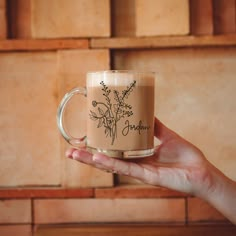 a hand holding a coffee mug with flowers on it