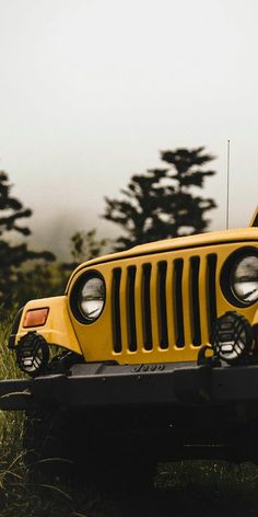 a yellow jeep is parked in the grass