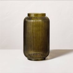 a green vase sitting on top of a white table