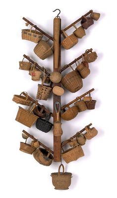 an arrangement of baskets and other items hanging from a ceiling rack on a white wall