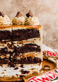 a large piece of cake sitting on top of a wooden table next to a candy bar