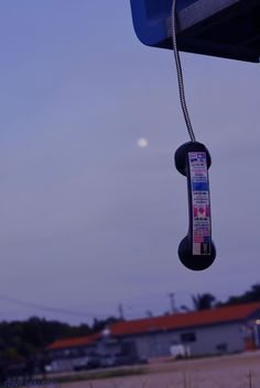 an old phone hanging from the side of a building in front of a blue sky